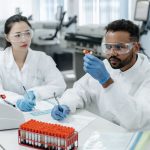 Dois cientistas analisam amostras e registram dados em um laboratório de pesquisa.
