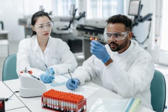 Dois cientistas analisam amostras e registram dados em um laboratório de pesquisa.