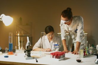 Dois pesquisadores trabalham com equipamentos e amostras em um laboratório de pesquisa.