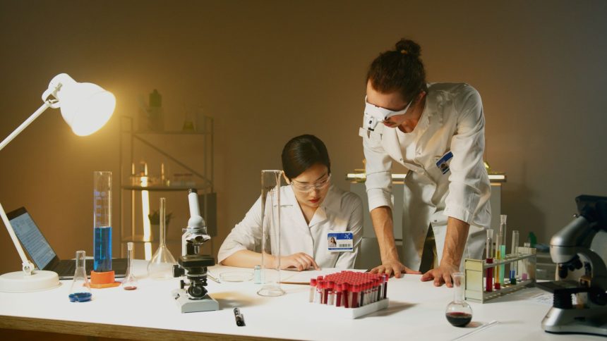 Dois pesquisadores trabalham com equipamentos e amostras em um laboratório de pesquisa.